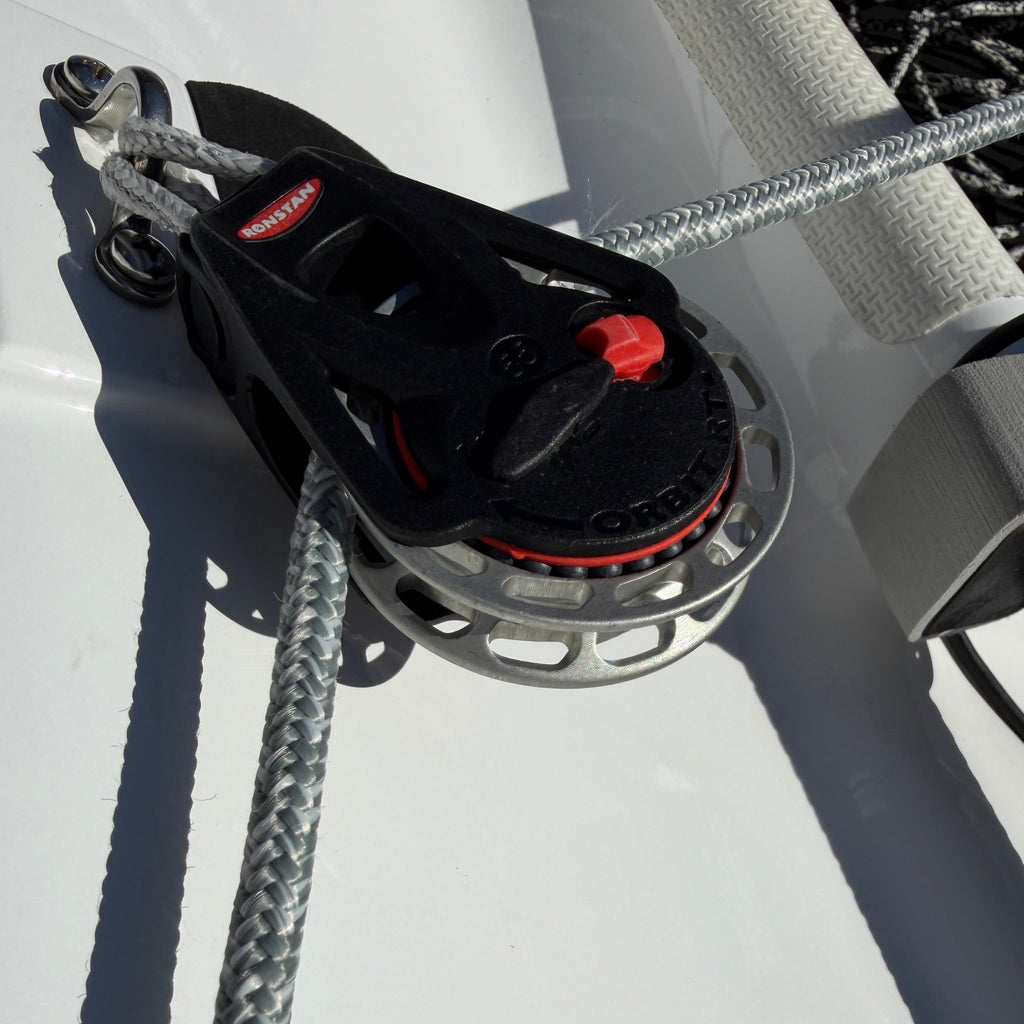 Close-up of a boat winch with rope on a white surface