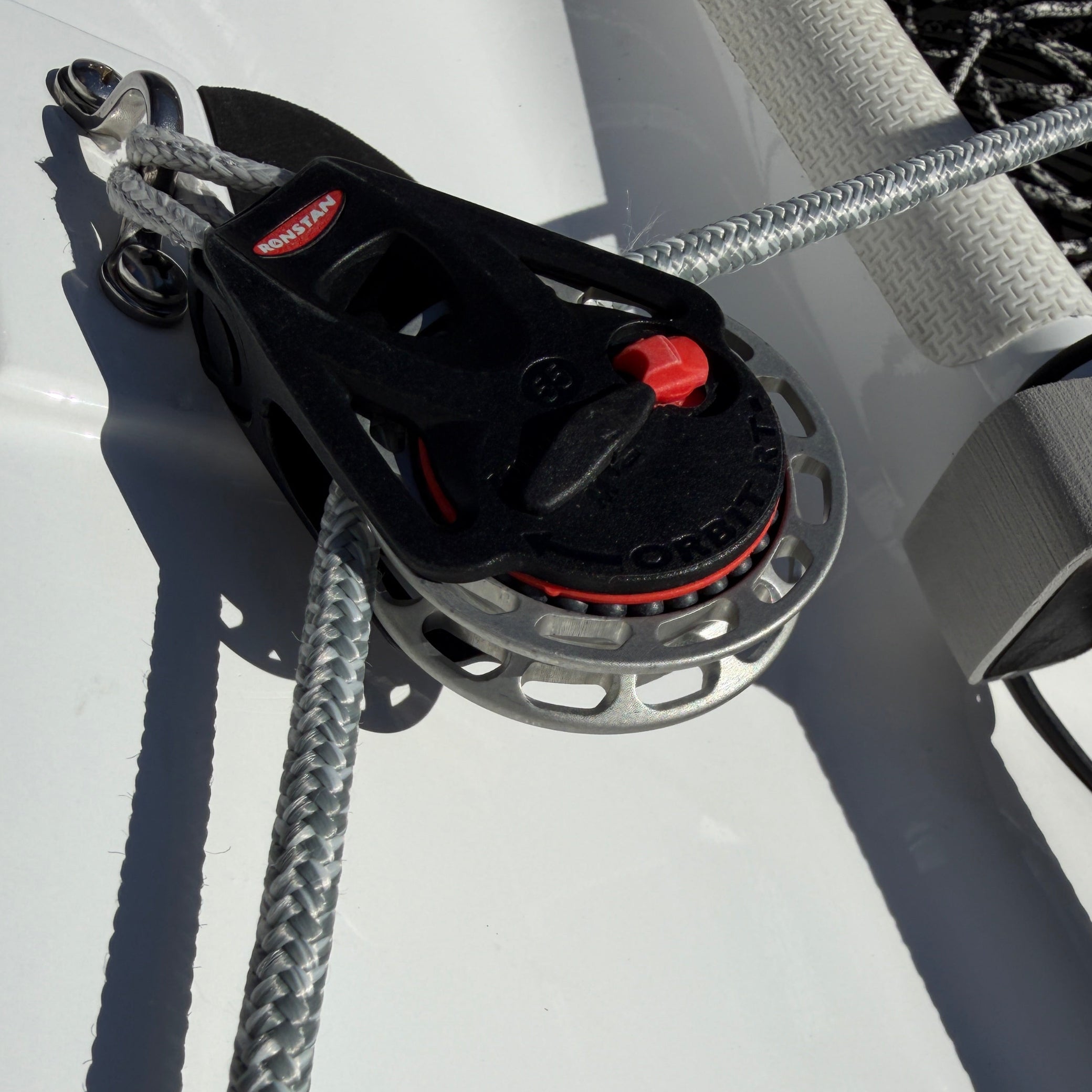 Close-up of a boat winch with rope on a white surface